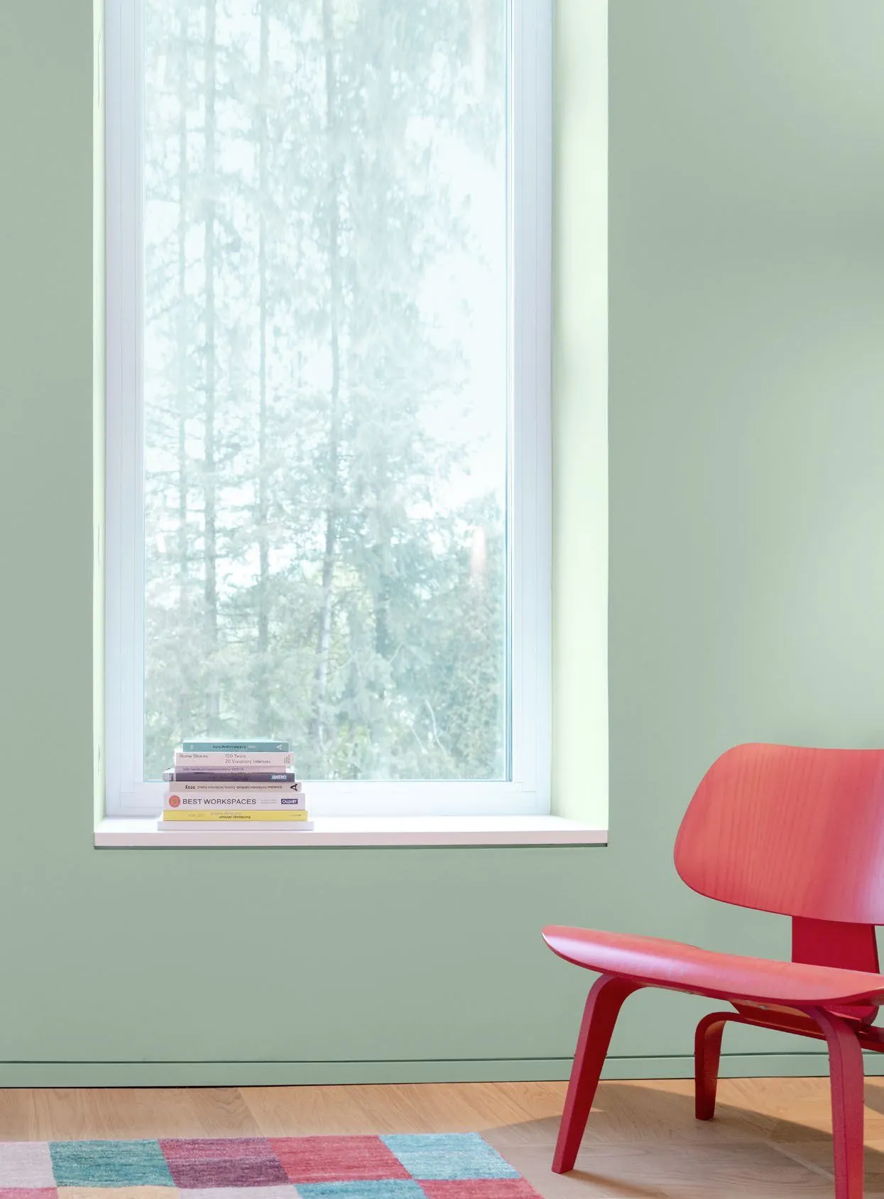 Phòng tường xanh với ghế đỏ Le Corbusier và công tắc LS 990